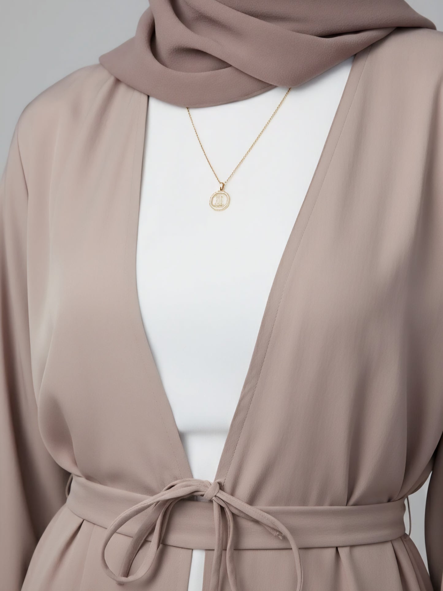 Premium beige two-piece abaya made from soft luxury fabric with belt and scarf, handcrafted in Dubai