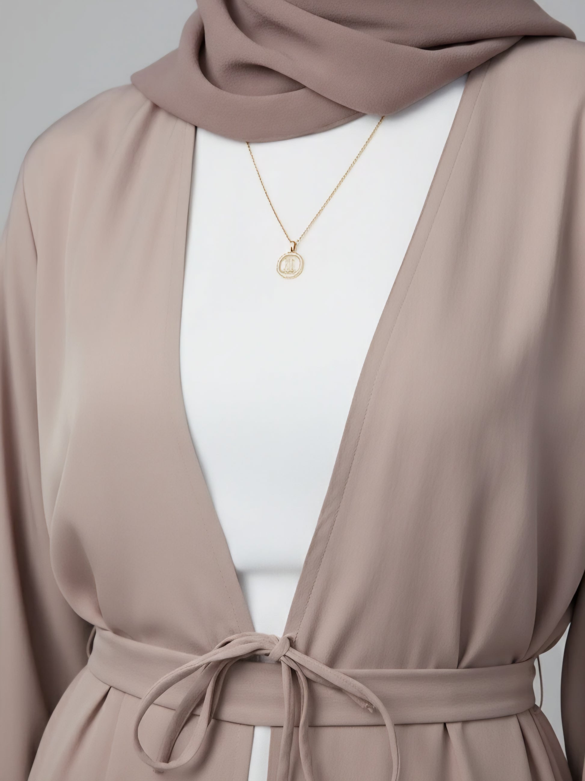 Premium beige two-piece abaya made from soft luxury fabric with belt and scarf, handcrafted in Dubai